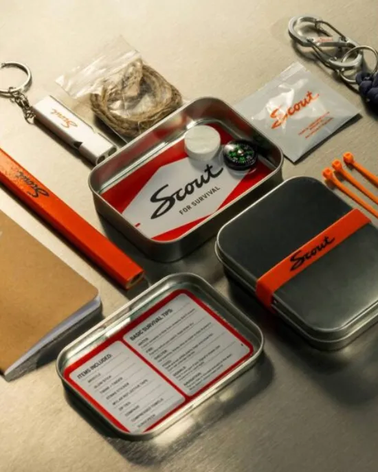 Scout Motors branded small, tin survival kit with carpenters pencil, light keychain, zip ties, cleaning wipe, S key ring, and notepad.